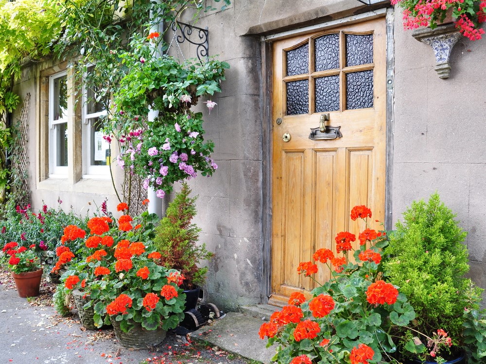 mandjes met bloemen aan voordeur cottage